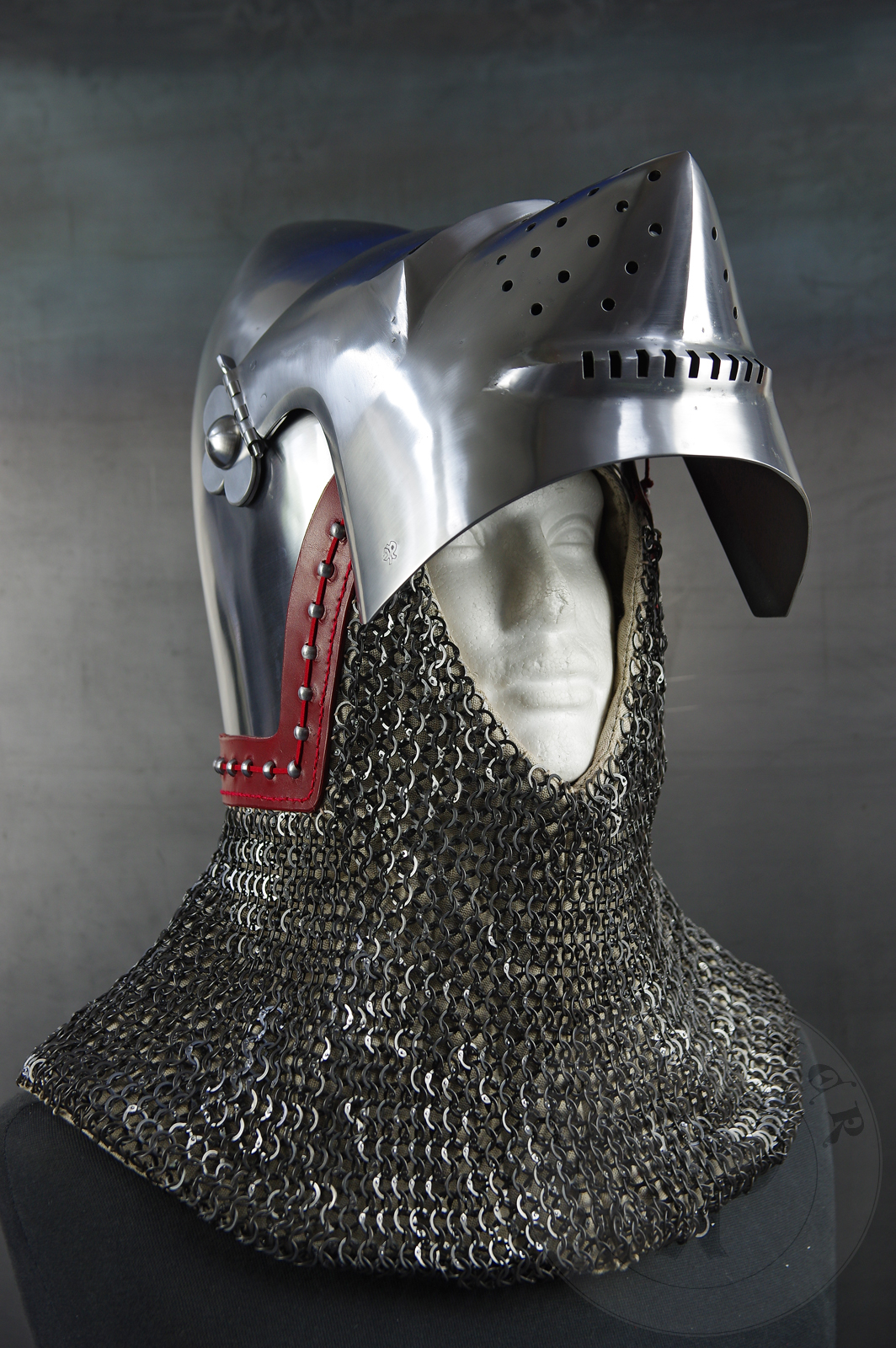 Przybica starszego typu z zason typu psi pysk wzorowana na przedstawieniu zbrojnego z otarza z Thouzon, 1410 rok, obecnie w muzeum w Luwrze. Hem wykonany z wysokiej jakoci stali niskowglowej oraz ulepszony cieplnie do 36-38 HRC./Visored bascinet based the depitc of men-at-arms from Thouzon altarpiecie (circa 1410) in Louvre Museum. Made of high quality mild steel and quenched to 36-38 HRC.